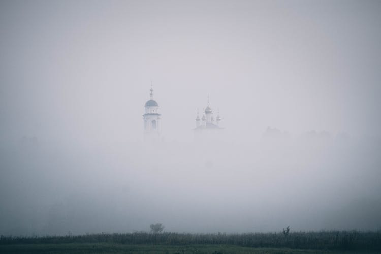 Towers Of A Castle Emerging From A Dense Fog 