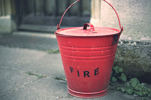 Free Rustic red fire bucket on a stone surface, evoking vintage charm and nostalgia. Stock Photo