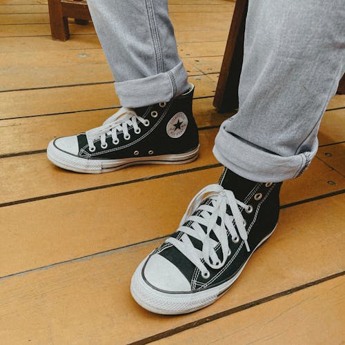 Free Close-Up Shot of a Person Wearing Black Converse Sneakers Stock Photo