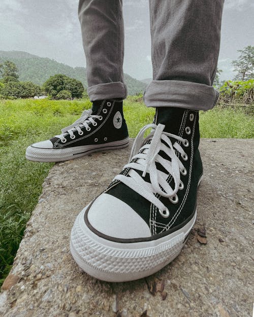 Close-Up Shot of a Person Wearing Black Converse Sneakers