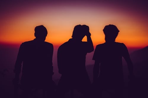 Free Silhouette of Men Standing on Open Area Golden Hour Photography Stock Photo