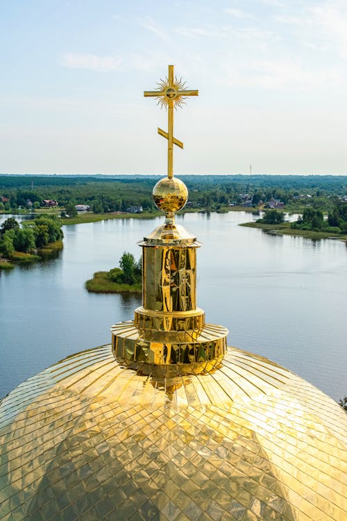 Gold Cross on Top of a Building Near the Lake