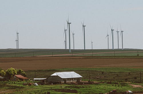 Windmills near a Farm in the Countryside