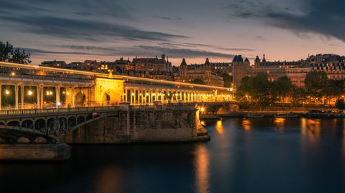 Free A stunning view of an illuminated bridge over the Seine River in Paris, capturing the city's night ambiance. Stock Photo