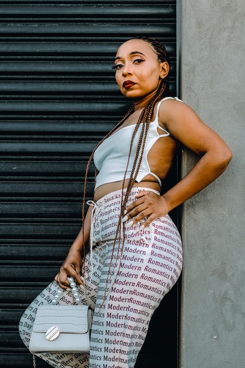 Free Stylish woman posing in modern fashion against a city backdrop, showcasing unique style. Stock Photo
