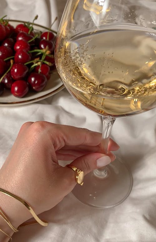 Seseorang Memegang Gelas Bening Dengan Anggur