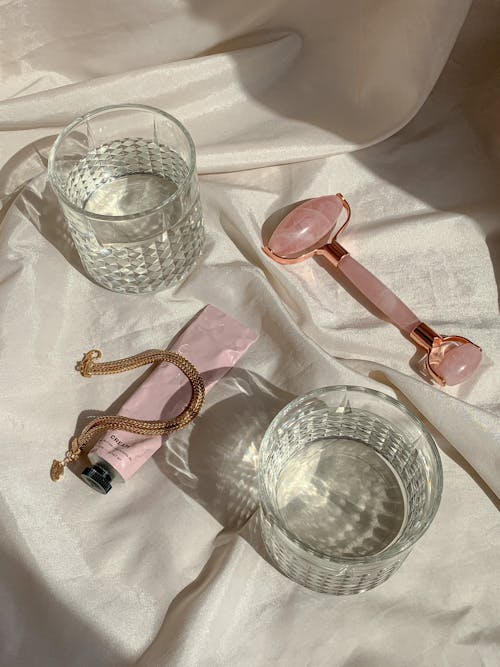Glasses and Beauty Products on White Sheets