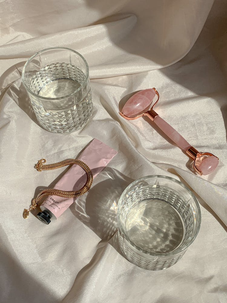 Glasses And Beauty Products On White Sheets