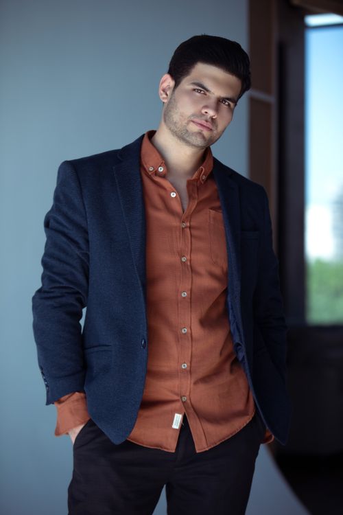 Free Portrait of a man in a blazer posing indoors with a thoughtful expression. Stock Photo
