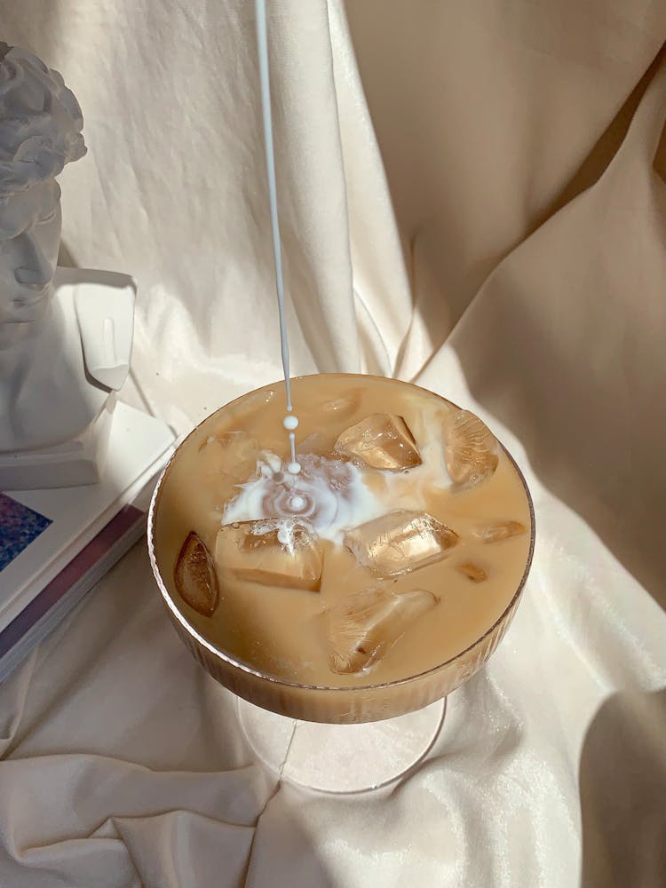 Pouring Milk On Iced Coffee