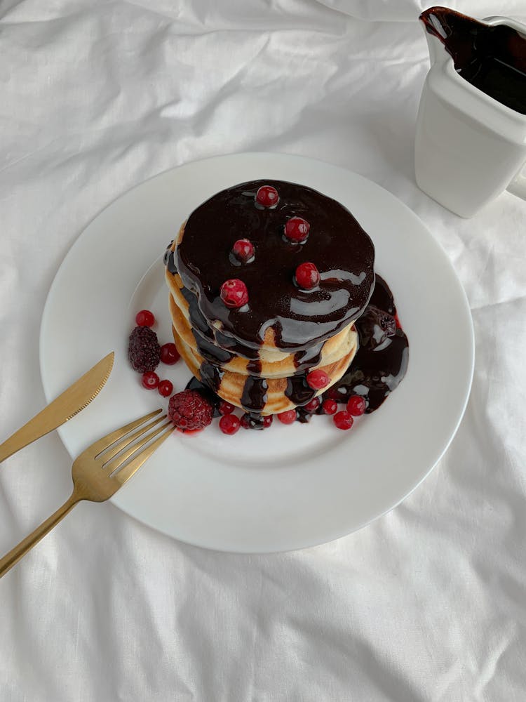 A Stack Of Pancakes With Chocolate Syrup 