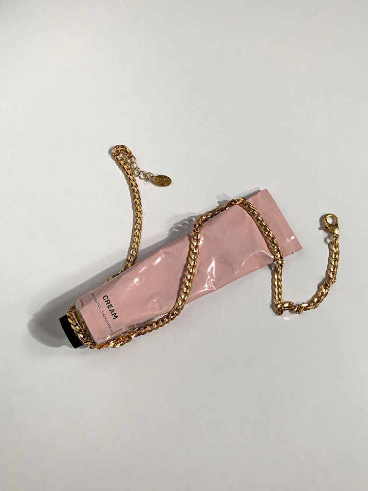 Gold And Pink Bracelet On White Surface