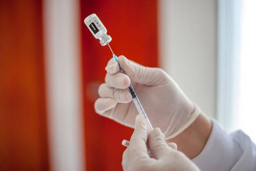 Free Healthcare professional preparing vaccine syringe with precision and care. Stock Photo