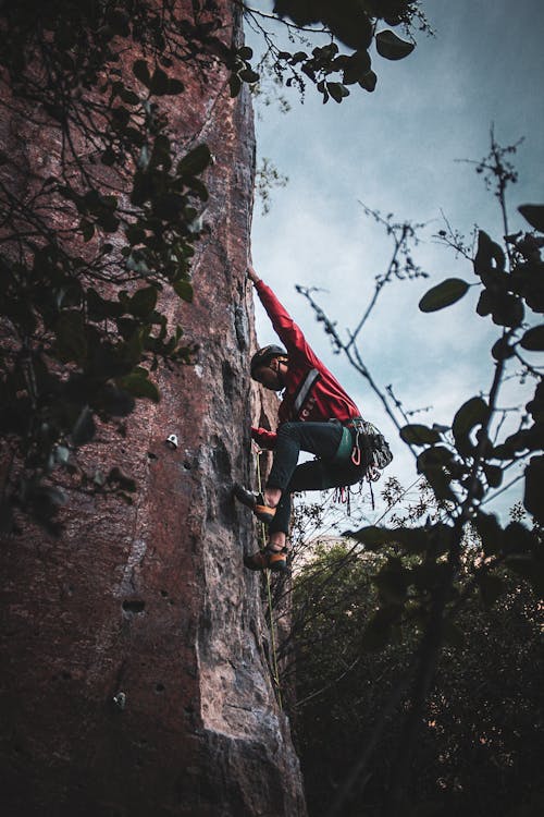 Free A Man Climbing a Rock Wall Stock Photo