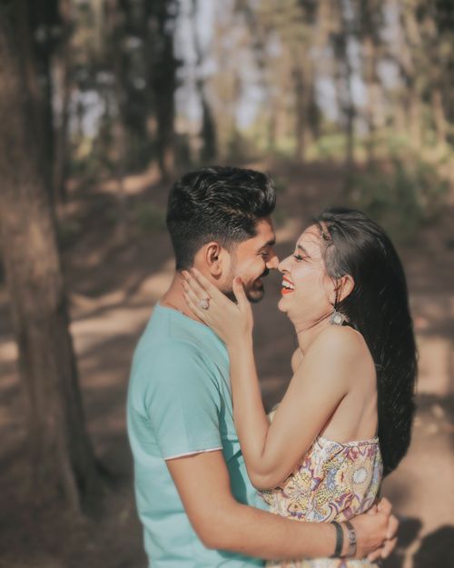 Free A joyful couple shares a loving moment in a sunlit forest, embracing and laughing. Stock Photo