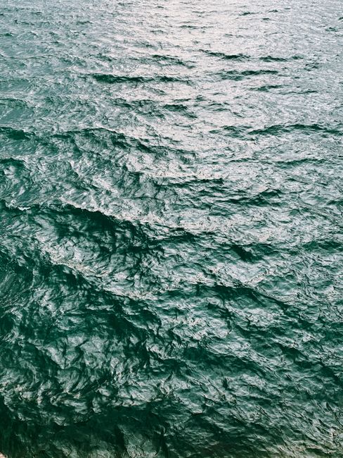 A tranquil view of ocean waves glistening under the daylight, creating a soothing seaside atmosphere.