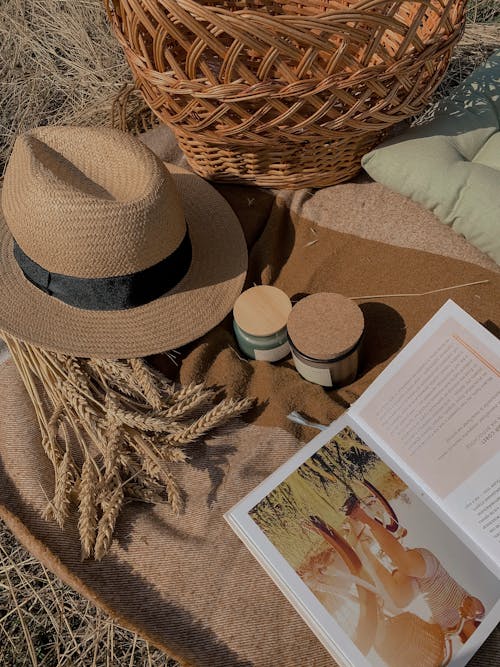 Brown Straw Hat, Glass Jars and an Open Book on a Picnic Blanket