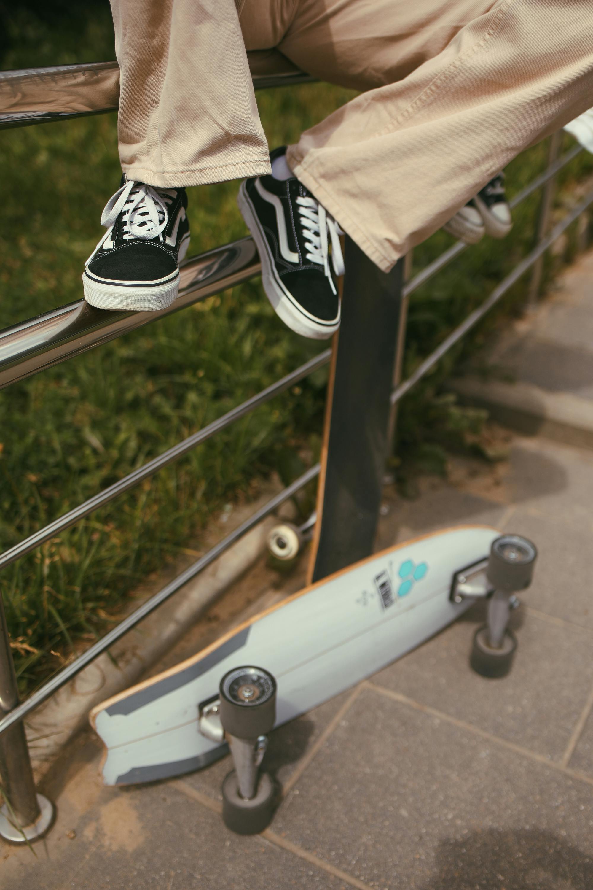 Person in Brown Pants and Black and White Sneakers Riding on White Bicycle