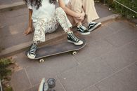 Woman in White Dress and Black and White Converse All Star High Top Sneakers Sitting on on on on on