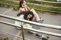 Woman in White Long Sleeve Shirt Lying on White Metal Bench