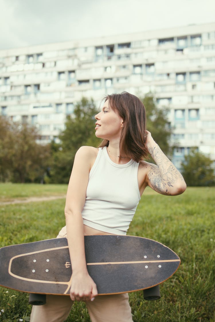 Woman In White Tank Top Holding A Long Board