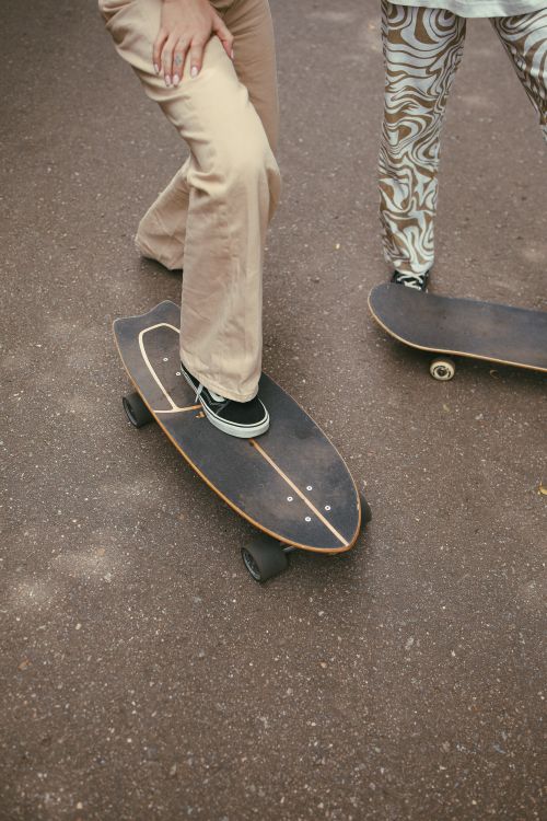 Free Two people skateboarding on a pavement, showcasing fashion and street culture. Stock Photo