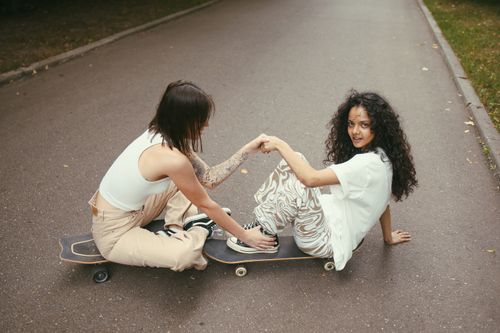 Free Two women skateboarding and enjoying a fun moment outdoors. Stock Photo