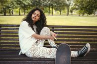 Woman in White Robe Sitting on Bench