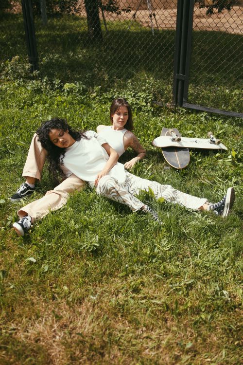 Free Two female friends relaxing outdoors with skateboards, enjoying a sunny day. Stock Photo