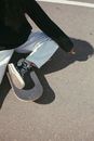 High-Angle Shot of a Person Sitting on Skateboard while Smoking Cigarette