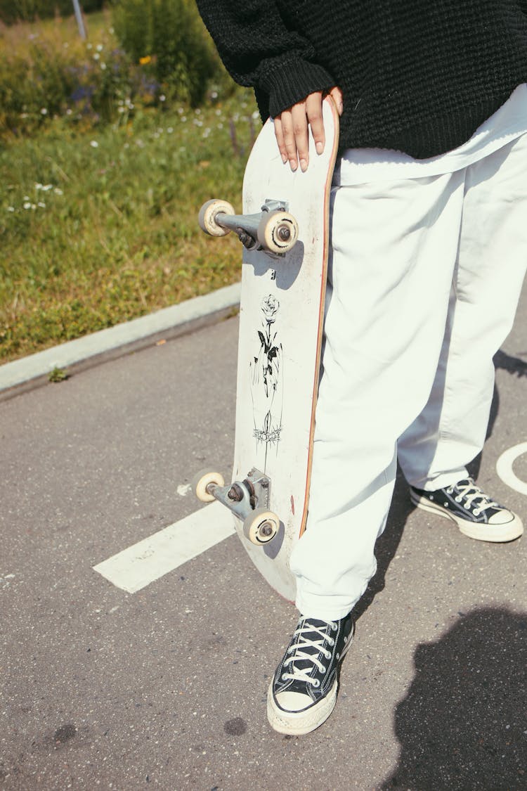 Person Standing Holding A Skateboard 