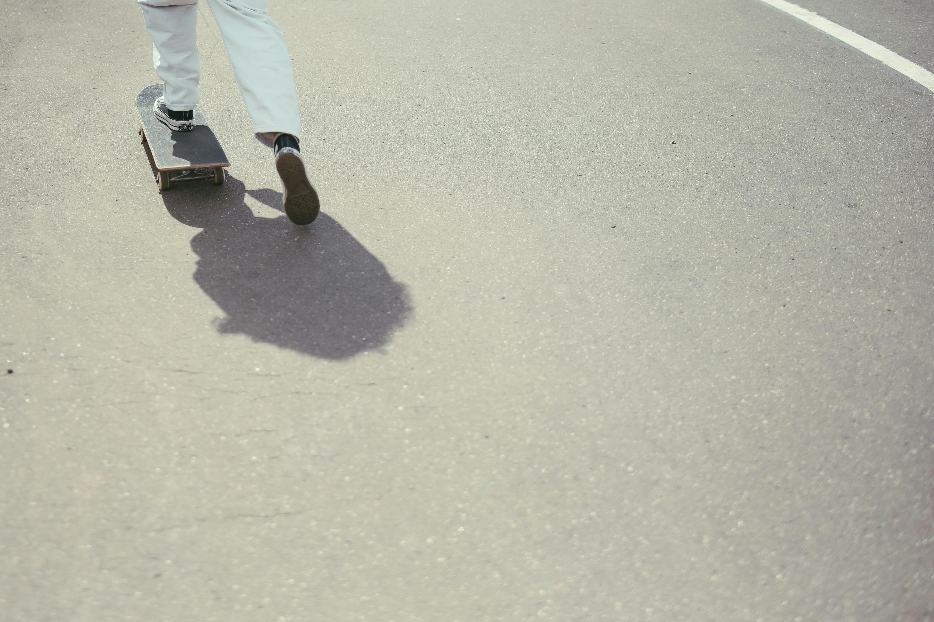A person skateboarding on a smooth road surface, showcasing dynamic motion.