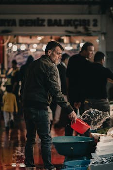 A man working at a bustling fish market in Istanbul, Turkey, with a focus on local culture and daily life.