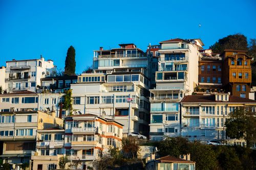 Free Captivating view of hillside residential buildings under a vibrant blue sky, showcasing modern architectural design. Stock Photo