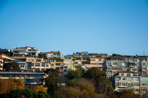 Free Charming urban hillside neighborhood with colorful apartment buildings under a clear blue sky. Stock Photo