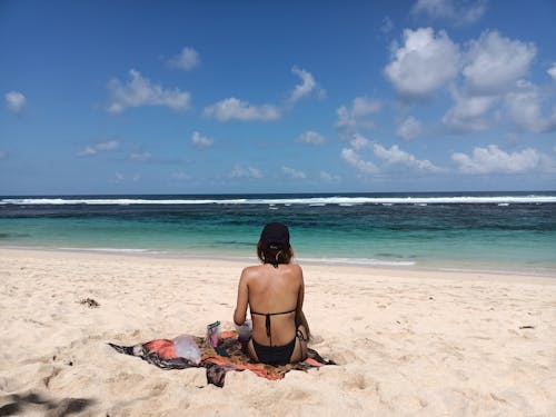 Woman in Black Bikini Sitting on Beach 