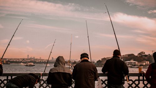 Free Back view of fishermen with rods on Galata Bridge during sunset in Istanbul. Stock Photo