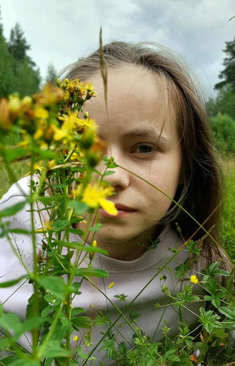 A Girl With Half Face Covered By Yellow Flowers