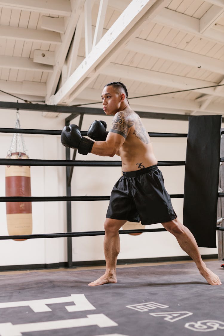 A Man In Black Shorts With Gloves Training For Boxing