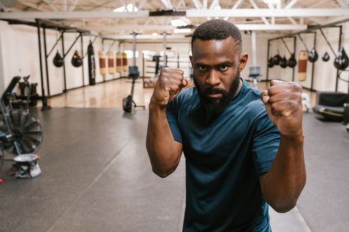 Free Focused boxer in an indoor gym practicing fighting stance for training. Stock Photo