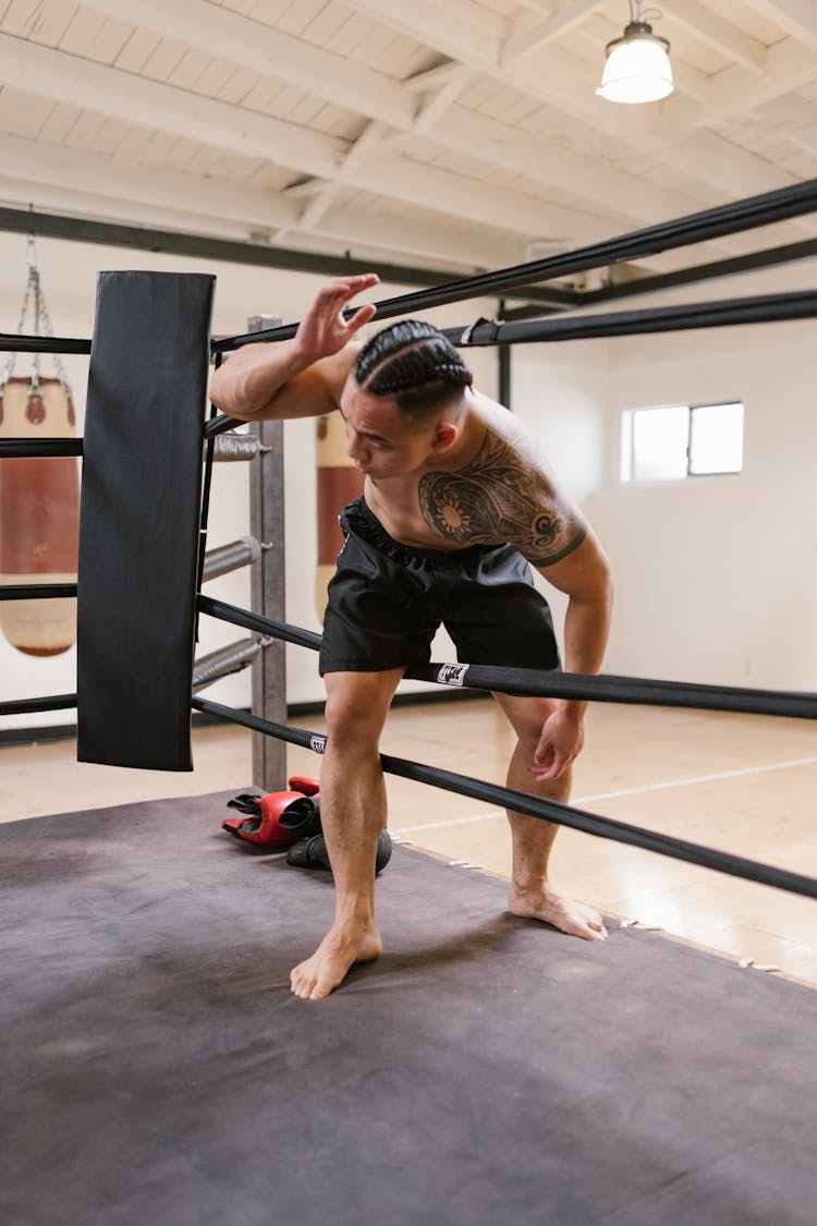 A Man In Black Shorts Going Inside The Boxing Ring