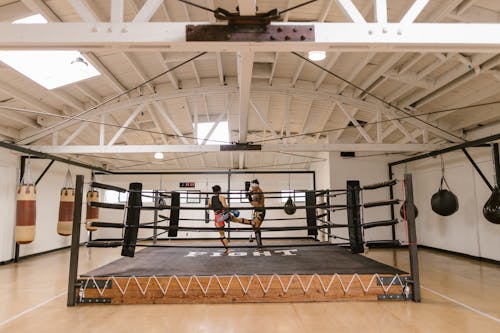 A Man and a Woman Sparring Inside the Boxing Ring