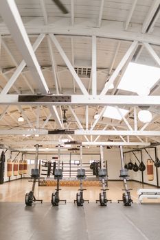 A modern boxing gym featuring punching bags, boxing ring, and exercise equipment. Bright and inviting.