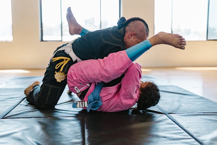 A Pair Of Taekwondo Athletes Sparring On The Mat