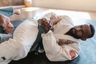 Man in White Long Sleeve Shirt Lying on Black Mattress