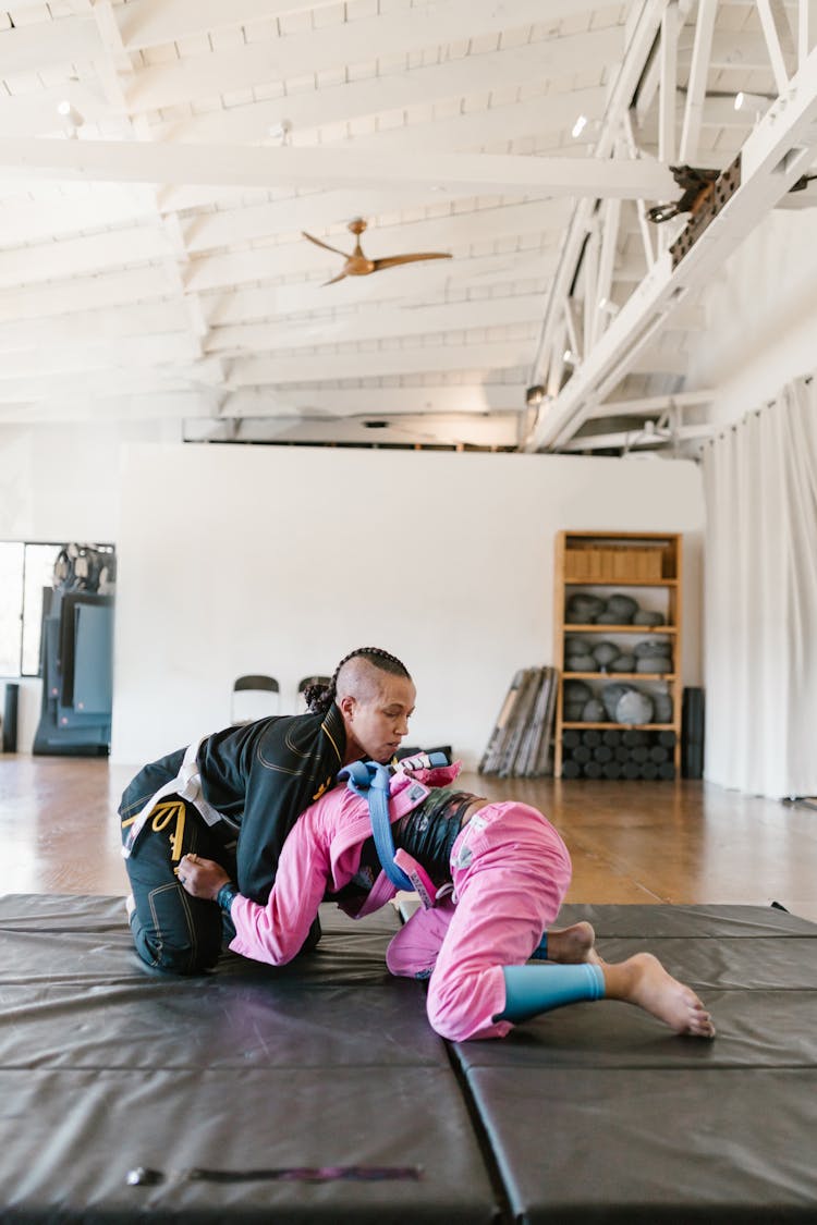 A Pair Of Taekwondo Athletes Sparring On The Mat