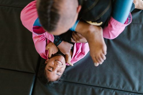 Free A top view of two individuals practicing martial arts grappling on a mat. Stock Photo