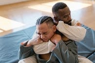 Man in Gray Coat Hugging Woman in Gray Coat