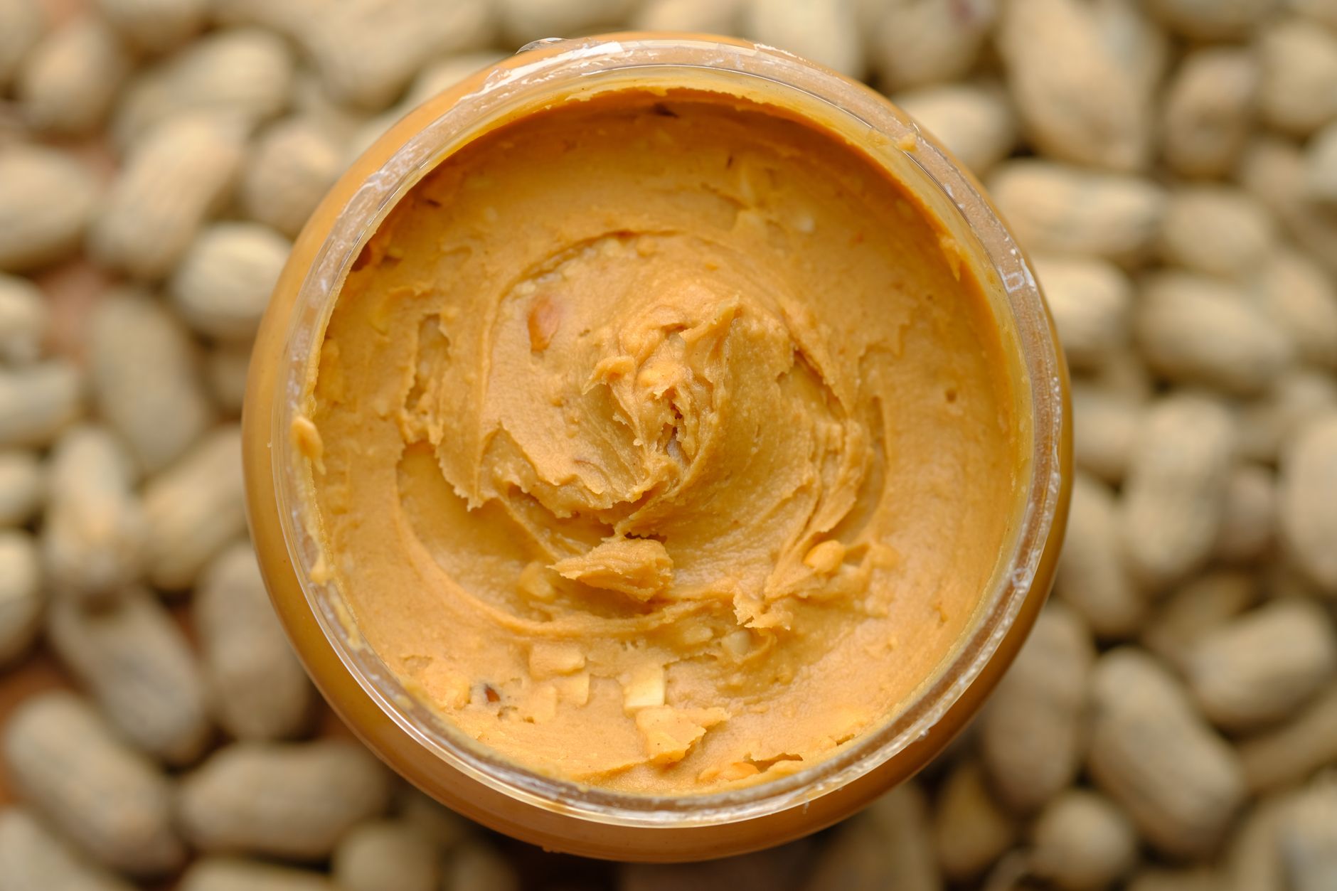 A jar of natural peanut butter with oil on top