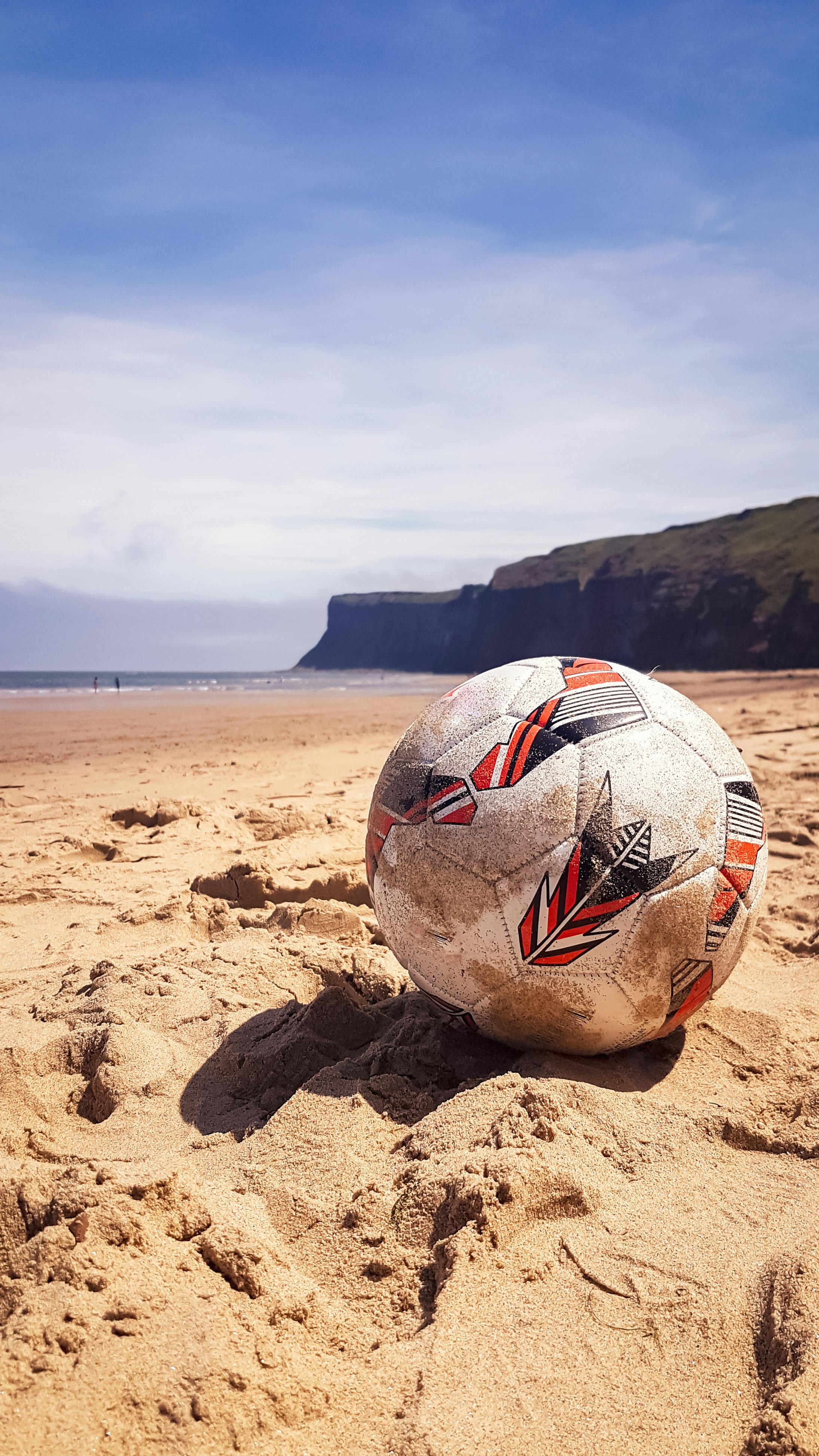 White and Red Soccer Ball on Brown Sand · Free Stock Photo